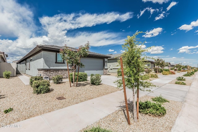 17376 W Via De Luna Dr, Surprise, AZ 85387 - view of front of home with fence, stone siding, a garage, stucco siding, and driveway