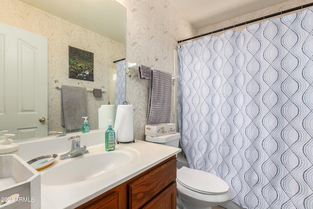 bathroom with toilet, vanity, and a shower with curtain