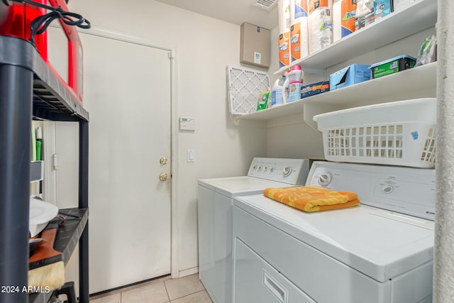 clothes washing area with washing machine and clothes dryer and light tile patterned floors