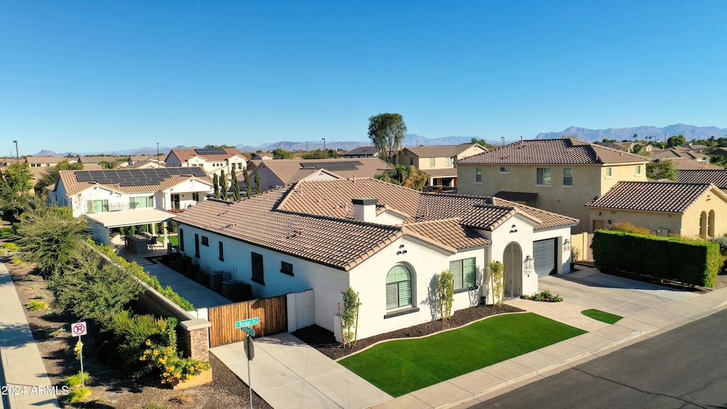 view of front facade featuring a mountain view, a garage, and a front lawn