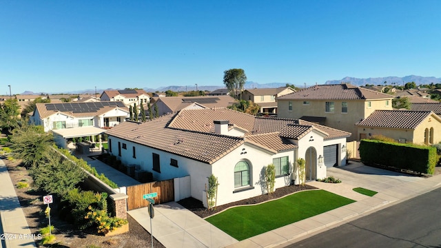 view of front facade featuring a mountain view, a garage, and a front lawn