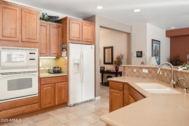 kitchen featuring tasteful backsplash, sink, white appliances, and light tile patterned flooring