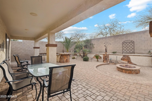 view of patio / terrace with an outdoor kitchen and a fire pit