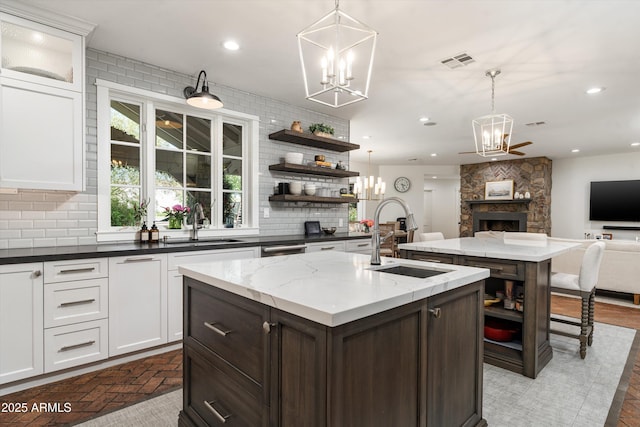 5112 N 41st St, Phoenix, AZ 85018 - kitchen featuring a chandelier, a stone fireplace, a kitchen island with sink, a sink, and open shelves