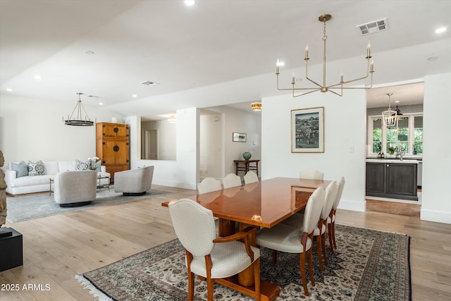 5112 N 41st St, Phoenix, AZ 85018 - dining room with a chandelier, recessed lighting, wood finished floors, and baseboards