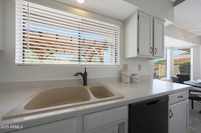 kitchen with black dishwasher, a sink, white cabinetry, and light countertops