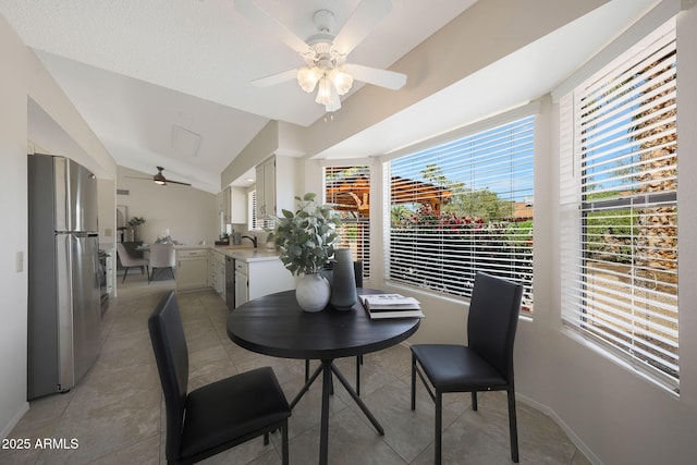 dining room with light tile patterned flooring, a ceiling fan, and lofted ceiling