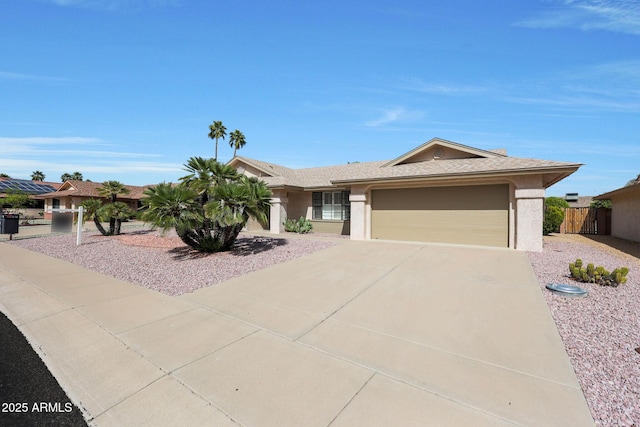 ranch-style home featuring concrete driveway, stucco siding, an attached garage, and fence