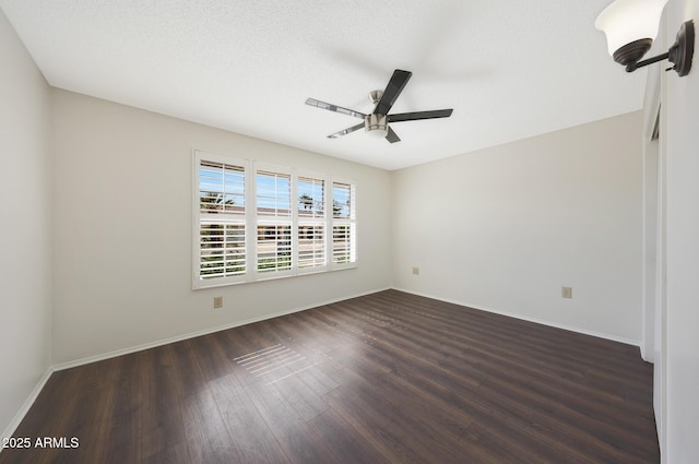 unfurnished room with a ceiling fan, wood finished floors, and baseboards