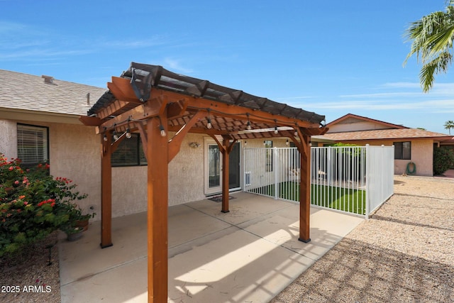 view of patio with a pergola and fence