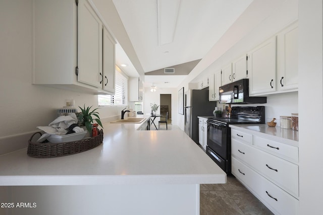 kitchen with vaulted ceiling, black appliances, a sink, white cabinetry, and visible vents