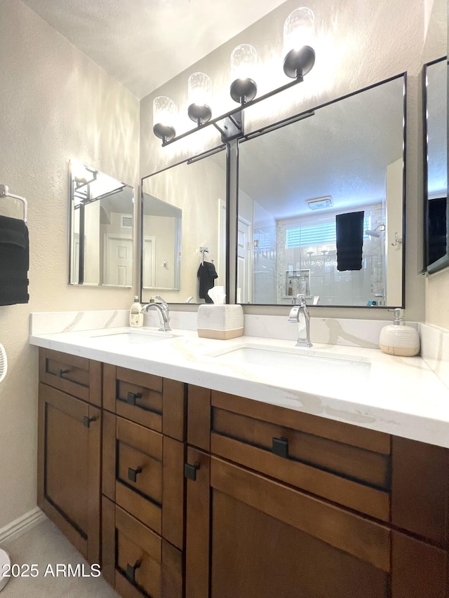 9807 W Mcrae Way, Peoria, AZ 85382 - bathroom with a sink, double vanity, a textured wall, and tiled shower