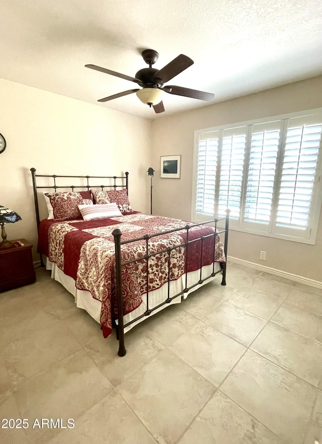 9807 W Mcrae Way, Peoria, AZ 85382 - bedroom with light tile patterned floors, a textured ceiling, baseboards, and a ceiling fan