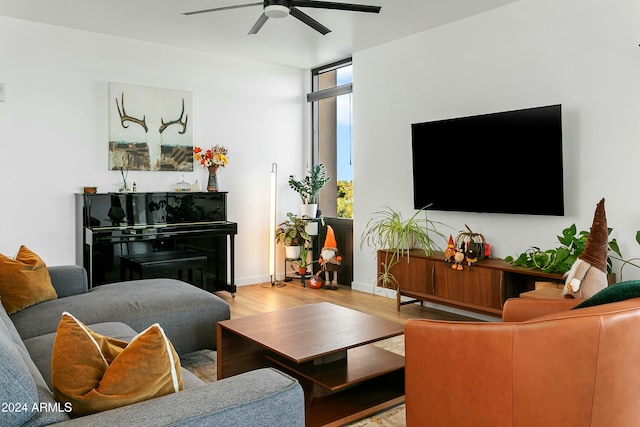 living room featuring ceiling fan, light hardwood / wood-style floors, and floor to ceiling windows