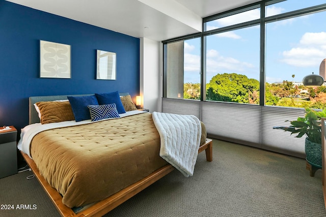 bedroom featuring carpet flooring and a wall of windows