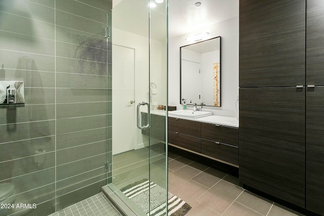 bathroom featuring tile patterned flooring, vanity, and a shower with door