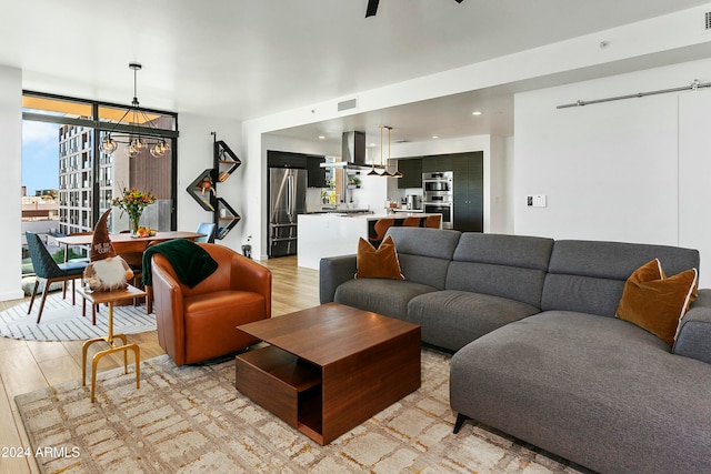 living room featuring a wall of windows, light hardwood / wood-style flooring, and an inviting chandelier