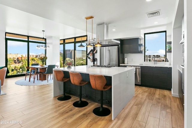 kitchen featuring appliances with stainless steel finishes, decorative light fixtures, and plenty of natural light