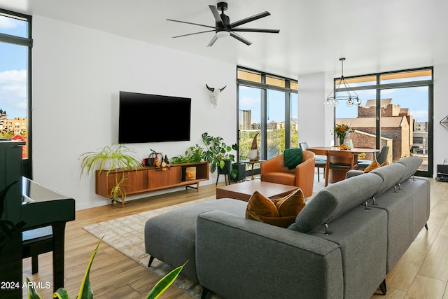 living room featuring floor to ceiling windows, light wood-type flooring, and plenty of natural light