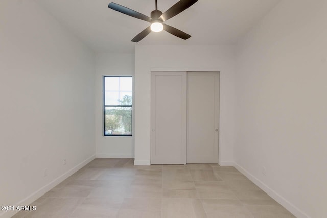 unfurnished bedroom with a closet, light tile patterned flooring, and ceiling fan