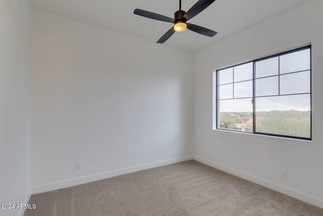 empty room featuring ceiling fan and light colored carpet