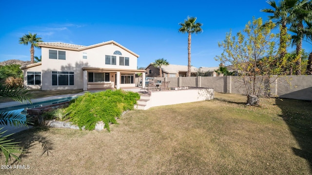 back of house featuring a yard and a patio