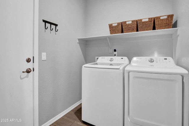 laundry area featuring separate washer and dryer, wood finished floors, laundry area, and baseboards