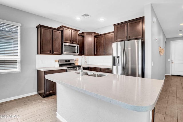 kitchen featuring a sink, dark brown cabinets, stainless steel appliances, and visible vents