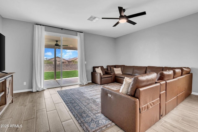 living room with wood tiled floor, ceiling fan, baseboards, and visible vents