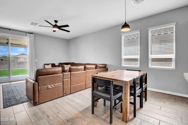 dining space featuring baseboards, visible vents, ceiling fan, and light wood-style floors