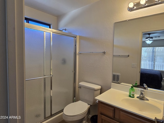 bathroom featuring vanity, toilet, ceiling fan, and a shower with shower door