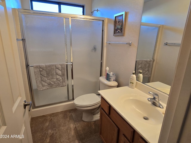 bathroom featuring vanity, toilet, and a shower with door