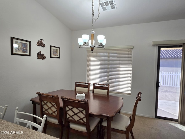 carpeted dining space featuring an inviting chandelier and lofted ceiling