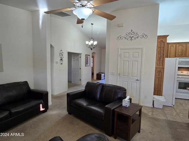 carpeted living room with high vaulted ceiling and ceiling fan with notable chandelier