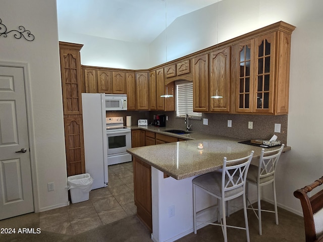 kitchen featuring white appliances, backsplash, sink, vaulted ceiling, and kitchen peninsula