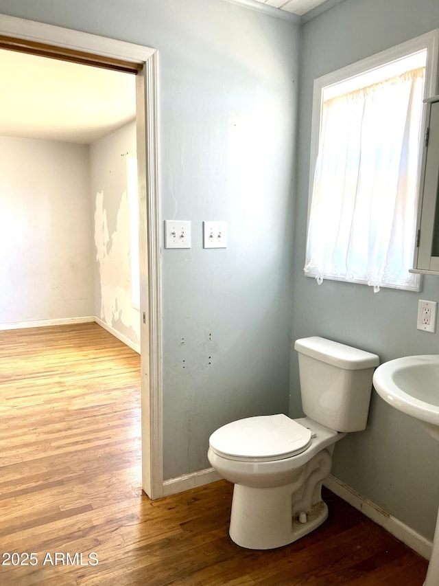 709 W Maple St, Winslow, AZ 86047 - half bathroom featuring wood finished floors, toilet, and baseboards