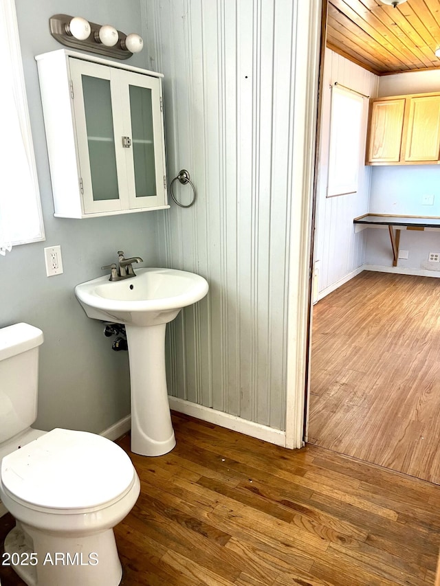 709 W Maple St, Winslow, AZ 86047 - half bathroom with wood finished floors, toilet, baseboards, and wood walls