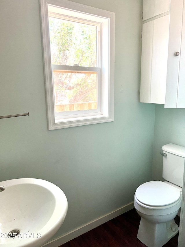 709 W Maple St, Winslow, AZ 86047 - half bath featuring a sink, toilet, baseboards, and wood finished floors