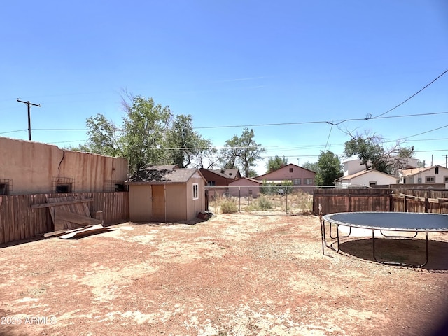 709 W Maple St, Winslow, AZ 86047 - fenced backyard featuring a trampoline, a shed, and an outbuilding