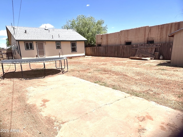 709 W Maple St, Winslow, AZ 86047 - rear view of property featuring a trampoline, a patio area, and fence