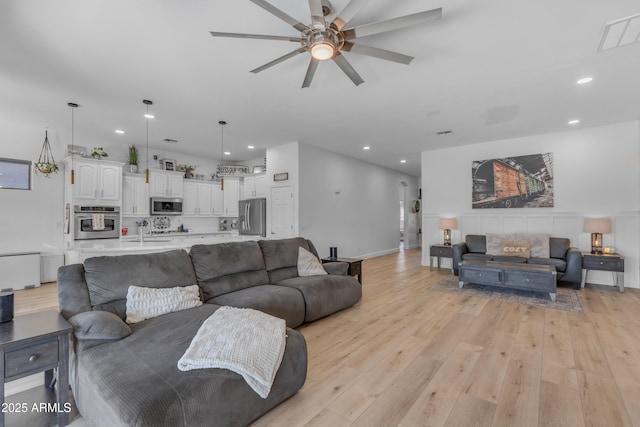 living room featuring a ceiling fan, recessed lighting, and light wood-type flooring