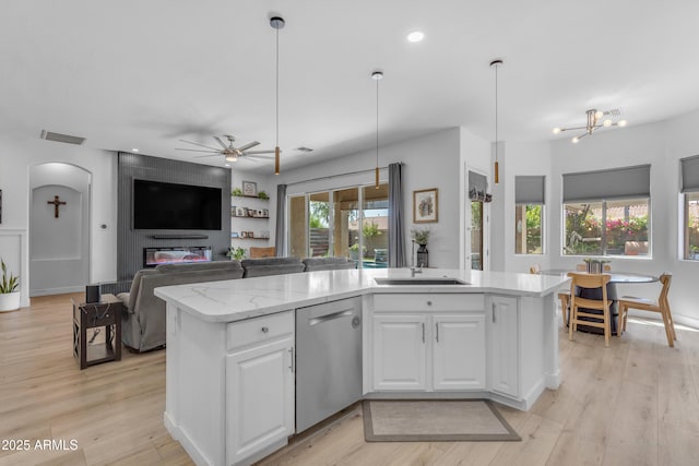 kitchen with a ceiling fan, visible vents, stainless steel dishwasher, open floor plan, and white cabinetry