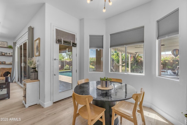 dining space featuring baseboards and light wood finished floors