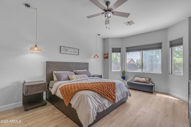 bedroom with baseboards, visible vents, multiple windows, and light wood finished floors