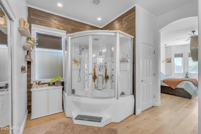 bathroom with ceiling fan, ensuite bath, wood finished floors, visible vents, and a stall shower
