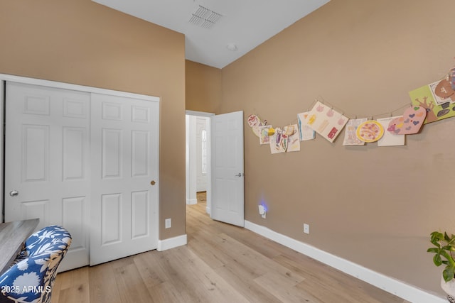 unfurnished bedroom with baseboards, a closet, light wood finished floors, and visible vents