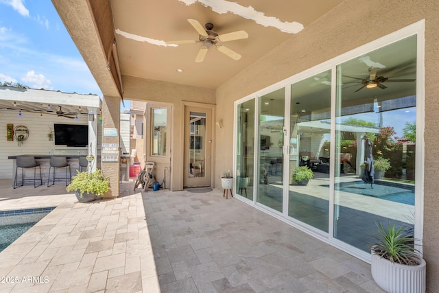 view of patio / terrace featuring outdoor dry bar, ceiling fan, and an outdoor pool