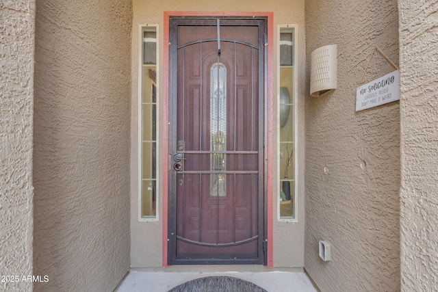 doorway to property featuring stucco siding