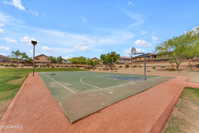 view of basketball court featuring community basketball court, fence, and a residential view