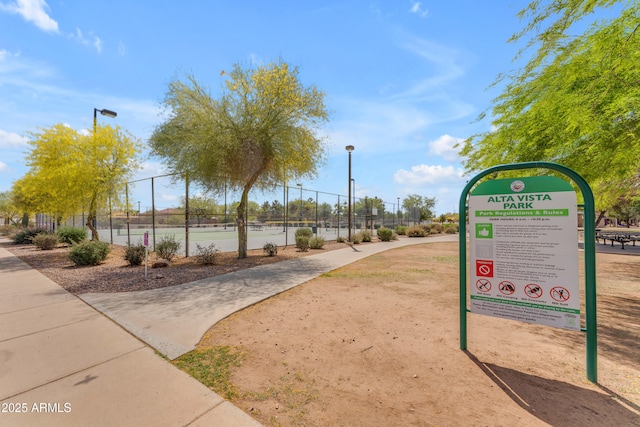 surrounding community with fence and a tennis court